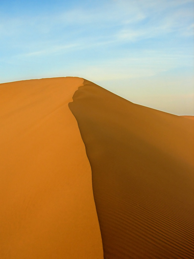 Golden sand dunes at sunset during evening desert safari