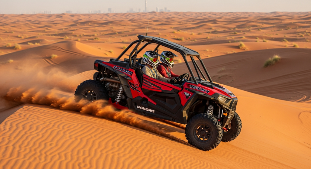 Red 2-seater Polaris RZR 1000cc dune buggy with a couple in full-face helmets and 4-point harnesses tracking across the red sand dunes of Lahbab near Dubai with all four tires firmly planted and a trailing dust cloud